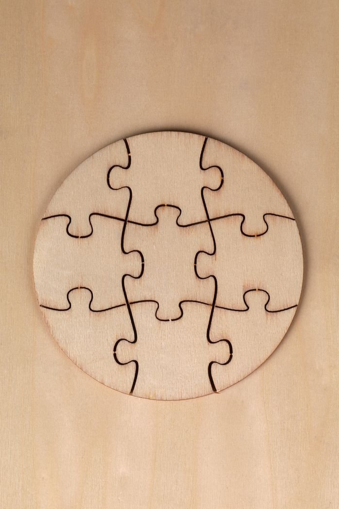ours-journey Round wooden puzzle lying flat on a light surface, minimalistic design.