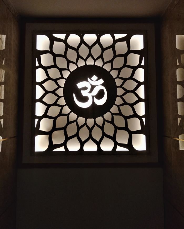 about-img An illuminated decorative panel with an OM symbol and intricate floral pattern, ideal for spiritual or architectural themes.