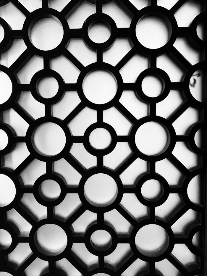services-01 Intricate geometric pattern with circles, creating an abstract and artistic black and white texture.
